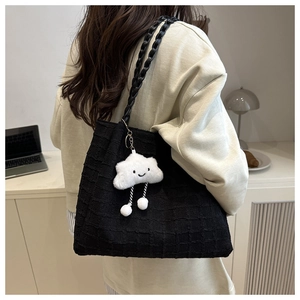 Detail of black quilted tote bag with unique 3D grid texture and cute cloud charm