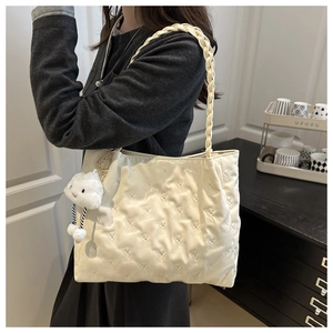 Quilted tote bag detail with embossed bear patterns and soft cloud plush pendant charm
