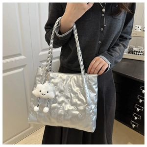 Close-up of silver quilted tote bag with bear texture and white cloud charm accessory
