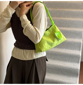 Close-up of bright green nylon shoulder bag with a small matching decorative pouch accessory