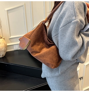 Detail shot of brown suede hobo bag with unique tie design and leather strap texture