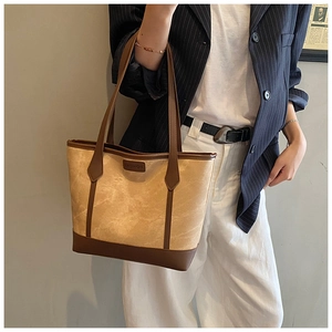 Detail of minimalist tote bag with marble texture finish and brown leather trim accents