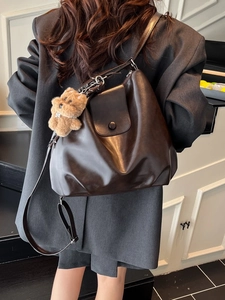 Brown large capacity leather shoulder bag with bear charm shown from back view