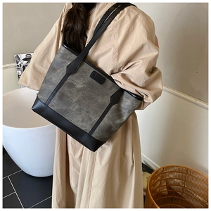 Dettaglio della borsa tote in tela opaca con etichetta fashion e bordo in pelle nera