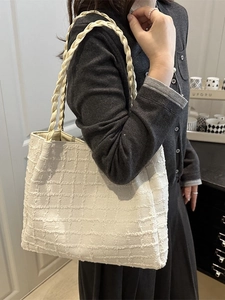 Minimalist white tweed tote bag with woven handles shown in a lifestyle setting