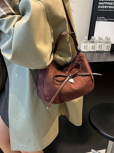 Borsa a mano in pelle scamosciata marrone con fiocco e ciondolo a cuore in studio sobrio