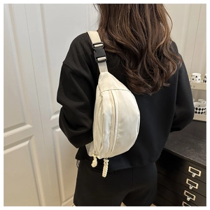 Detail of off-white crossbody bag featuring adjustable woven strap and dual zipper closure