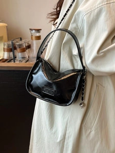 Chic black glossy chain crossbody bag with modern metallic Fashion plaque and round base