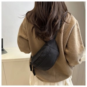 Back view of a model wearing a black crescent canvas crossbody chest bag for daily wear