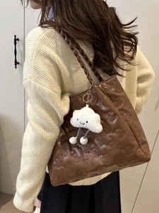 Brown quilted tote bag with bear pattern, woven strap, and white cloud charm decoration