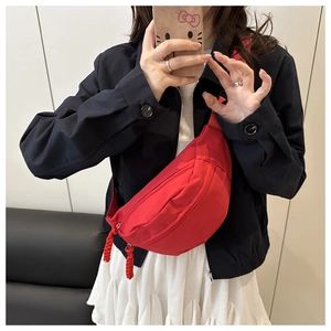 Mirror selfie showing a vibrant red canvas saddle bag worn as a trendy chest pack