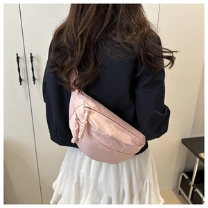 Detailed back view of pink nylon crossbody saddle bag with multiple zipper compartments