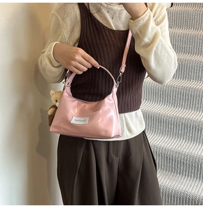Pink glossy patent leather underarm bag with cute plush bear charm and adjustable strap