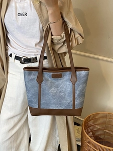 Blue denim and brown leather tote bag with FASHION label shown on model in trench coat