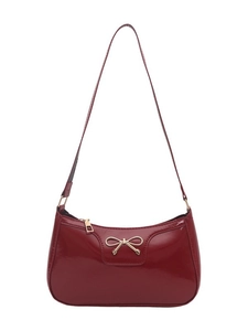 Glossy burgundy patent leather underarm bag with a decorative gold bow buckle