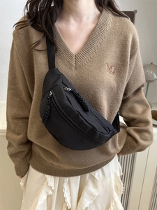 Black casual chest bag with woven zippers shown on a cross-body shoulder strap