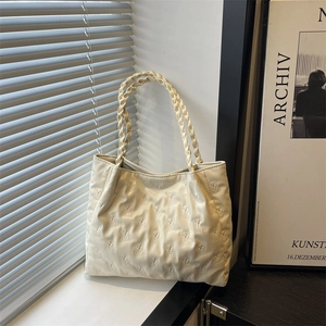 Minimalist beige tote bag featuring embossed bear patterns and woven straps for daily use