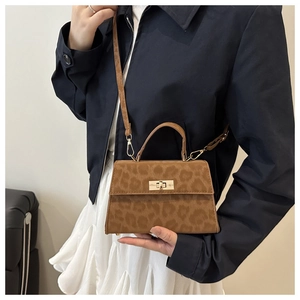 Detail of leopard print crossbody bag with gold twist lock and adjustable strap