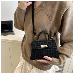 Detail of grey leopard print faux fur handbag with gold twist lock and black leather strap