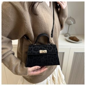 Detail shot of leopard print mini kelly bag with gold clasp and black shoulder strap