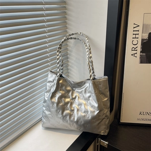 Silver metallic tote bag featuring 3D embossed teddy bear patterns and woven top handles