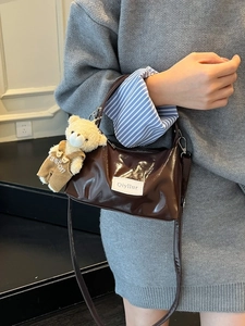 Dark brown glossy patent leather underarm bag with a cute teddy bear charm