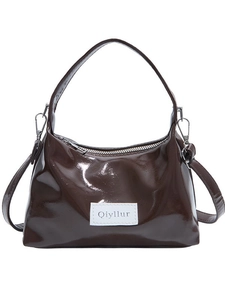 Glossy dark brown hobo bag with a white brand label and silver hardware on white background