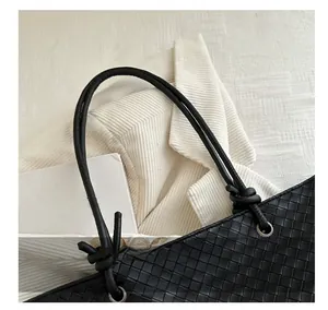 Detail of black woven leather texture and knotted cord handle with silver metal eyelet