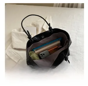 Overhead view of large capacity black woven leather tote bag showing internal storage space