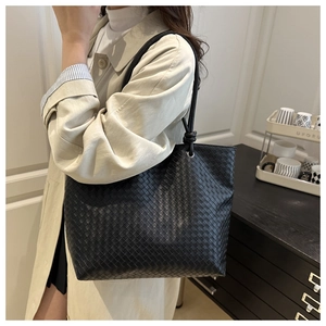 Close-up of black woven leather tote bag featuring classic Intrecciato craftsmanship detail