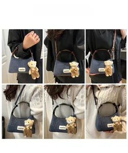 Lifestyle shots of denim crescent shoulder bag with bear charm and brown handle details