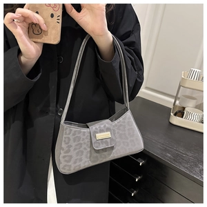 Détail du sac baguette gris à motif léopard avec boucle dorée et bandoulière élégante