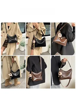 Sac hobo vintage minimaliste porté en bandoulière et à la main avec pompon doux