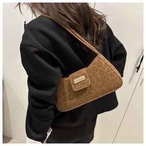 Détail d'un sac sous les bras vintage à motif léopard avec boucle dorée chic