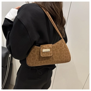 Vue latérale d'un sac porté épaule vintage imprimé léopard avec boucle dorée sur modèle