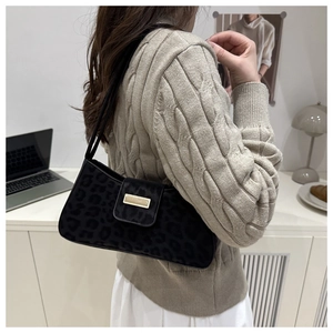 Detail der schwarzen Leoparden-Unterachseltasche mit goldener Metallschnalle am Model
