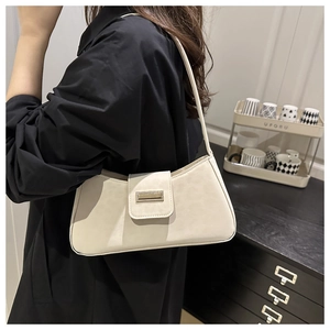 Détail du sac baguette en cuir blanc crème avec une boucle métallique dorée élégante