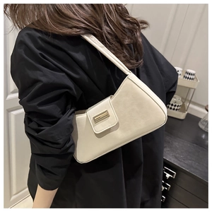 Sac à bandoulière chic blanc crème en similicuir mat porté avec une chemise noire