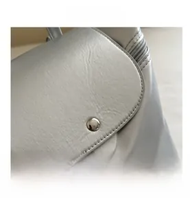 Dettaglio della texture in ecopelle grigio argento con chiusura magnetica d'argento e cerniera