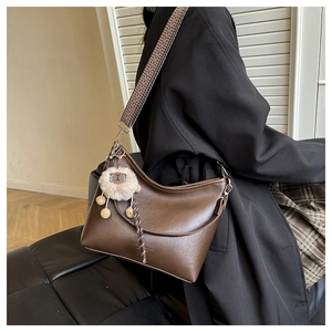 Vue détaillée d'un sac bandoulière vintage en cuir marron avec large sangle à motif