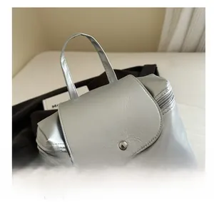 Dettaglio dello zaino in pelle metallizzata argento con manico largo e patta magnetica