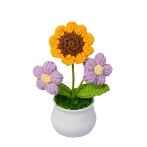 Handgemaakte gehaakte zonnebloem en paarse bloemen in een witte keramische stijl pot
