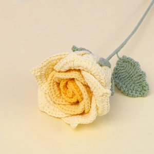 Close-up detail of a handmade crochet yellow rose with realistic knitted texture and stem