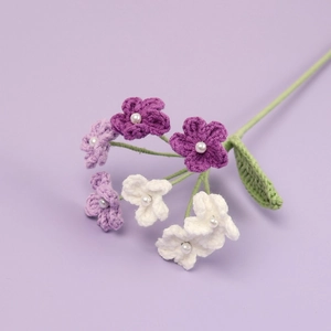 Detailed view of handmade crochet flowers in purple and white with pearl centers