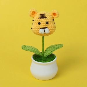 Detailed view of a handmade crochet tiger plant in a white ceramic pot for desk decor