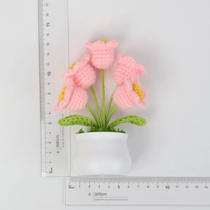 Detail showing height and width of a handmade crochet pink flower pot with ruler measure