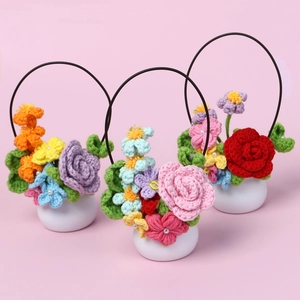 Vue détaillée de trois paniers de fleurs au crochet faits main dans des pots en céramique