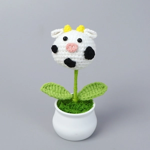 Handmade crochet potted plant featuring a cute cow design in a white ceramic pot
