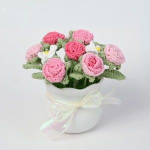 Detail of handmade crochet rose bouquet in white textured pot with a pink ribbon bow