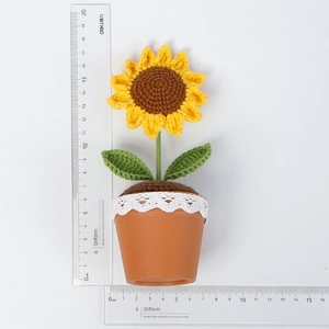 Handgemaakte gehaakte zonnebloem in pot met kant en liniaal voor de weergave van de maat